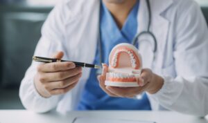 doctor showing a set of teeth with a fountain pen
